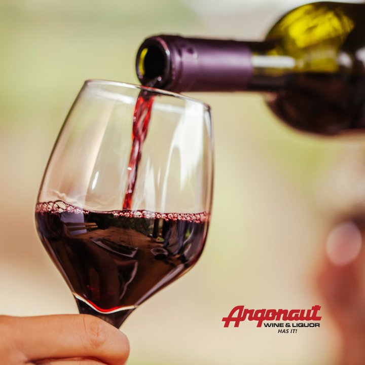 Wine being poured with the Argonaut Wine and Liquor logo